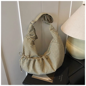 Detail of green gingham hobo bag featuring drawstring bow and adjustable shoulder strap