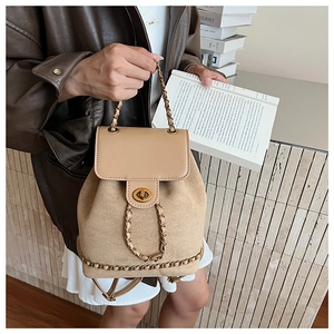 Detail of tan patchwork backpack featuring suede texture and gold chain link accents