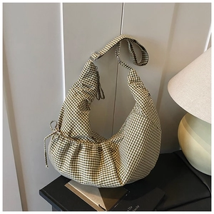 Detail of green gingham canvas hobo bag with drawstring texture and adjustable strap