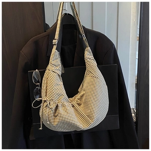 Detail of green and white gingham crescent bag featuring adjustable strap and drawstring