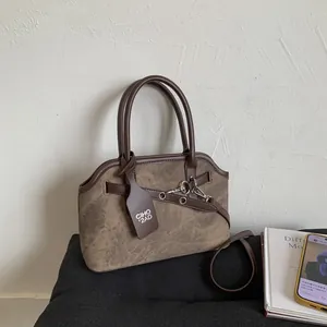 Detail of dark brown vintage handbag featuring matte texture and metal strap rings