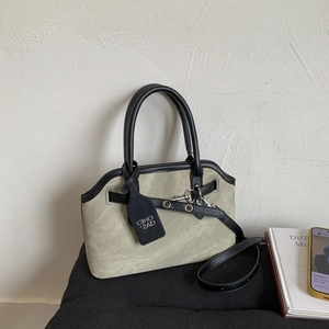 Detail of grey-green canvas handbag with black leather trim and silver metal hardware