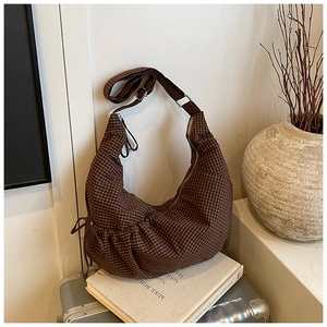 Detail of checkered hobo bag with adjustable strap on creative lifestyle background