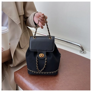 Close-up of black leather bucket backpack with gold chain details and twist lock