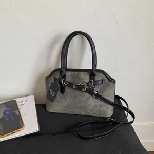 Close-up of vintage grey nubuck crossbody bag with black leather trim and metal ring detail