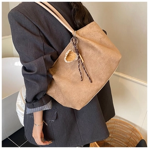 Detalle del bolso tote de ante camel con colgante trenzado y gran capacidad para mujer