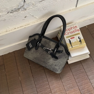 Detail view of vintage canvas handbag with leather trim and decorative metal hook