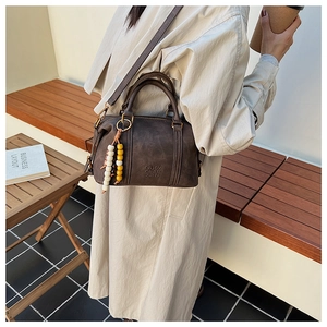 Close-up of vintage dark brown crossbody bag with wooden beads and a smooth matte finish
