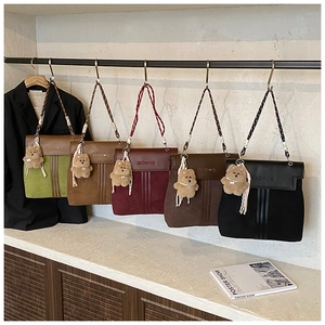 Row of leather patchwork backpacks in five colors with woven straps and plush charms