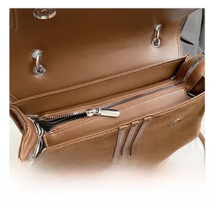 Detail view of the brown backpack interior with striped lining and silver zipper pocket