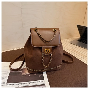 Detail of vintage brown suede backpack with gold chain strap and metal turn-lock closure