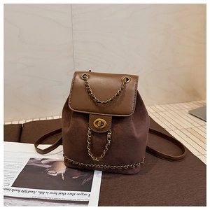 Detail of vintage brown backpack featuring matte texture and golden chain with twist-lock