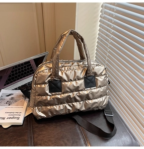 Détail du sac matelassé doré champagne avec bandoulière noire et patch en cuir carré