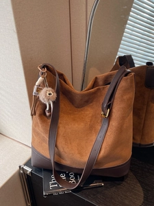 Vintage brown suede tote bag with leather straps and plush charm for daily commute