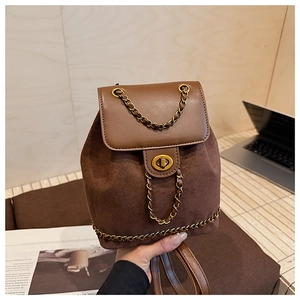 Close-up of vintage brown suede bucket backpack with gold chain details and twist lock