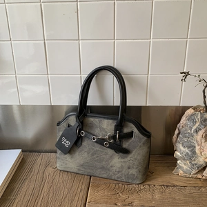 Detail shot of vintage grey canvas handbag featuring black leather trim and metal clasp