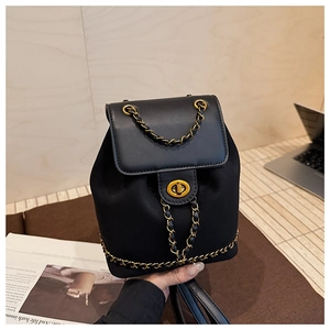 Detail of black mini bucket backpack with gold metal twist lock and leather chain