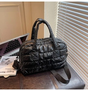 Gros plan détaillé d'un sac matelassé noir sur un bureau avec ordinateur portable
