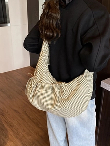 Green and white gingham large capacity cloud bag with drawstring closure worn by a model