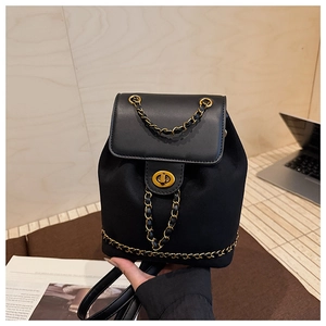 Detail of black drawstring backpack featuring gold chain trim and metallic turn-lock closure
