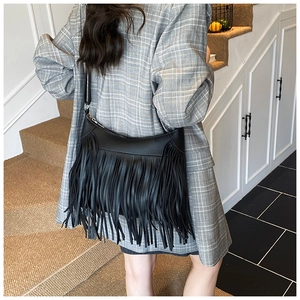 Vue détaillée du sac seau noir à franges montrant la texture et le mouvement sur le modèle