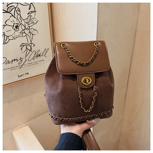 Detail of a brown vintage mini backpack featuring a metal chain trim and gold twist lock