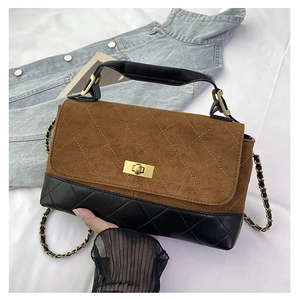 Detail of retro quilted bag with brown suede flap and golden rectangular twist lock