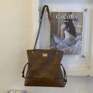 Détail du sac cabas marron vintage avec bandoulière chaîne et cordon de serrage latéral