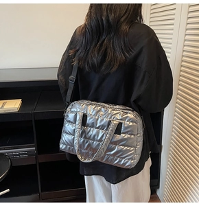 Sac à bandoulière matelassé argenté avec sangle noire réglable porté par le mannequin