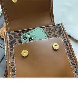 Detail view of brown leather bag with leopard lining and front pocket for smartphone