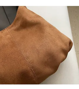 Detail of brown suede shoulder bag featuring premium texture and durable double stitching