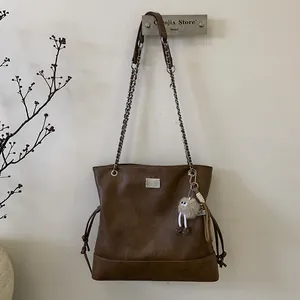 Gros plan sur le sac cabas vintage marron en similicuir texturé avec plaque métallique