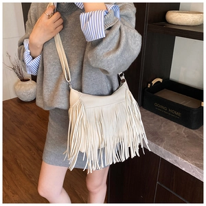 Détail du sac seau blanc cassé avec de longues franges et texture cuir grainé