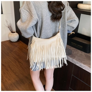 Détail du sac bandoulière crème avec de longues franges montrant la capacité et le style bohème