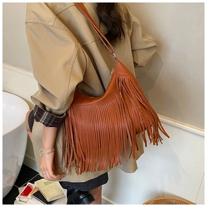 Detail of a brown fringe bucket bag with long tassels and premium pebbled leather texture