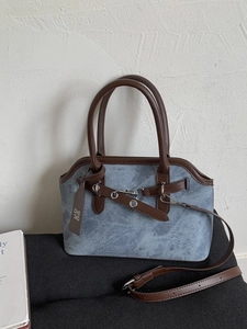 Retro blue-grey crossbody bag with brown handles and metal horsebit detail on display
