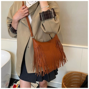 Vue détaillée des franges en cuir denses et de la fine bandoulière de ce sac marron