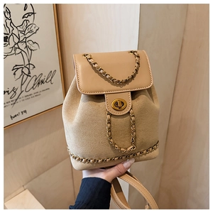 Detailed view of beige bucket backpack with gold chain strap and metal turn-lock closure