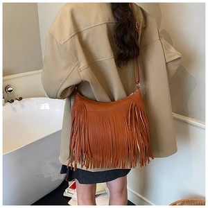 Gros plan du sac seau à franges caramel avec texture grainée et bandoulière réglable