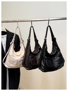 Detailed view of large leather tote bags in beige, brown and black with utility pockets