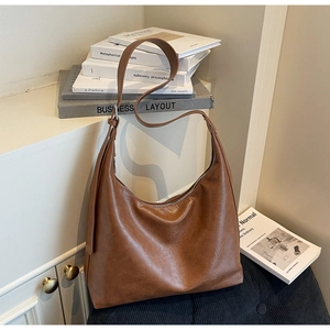 Detail view of brown faux leather hobo bag with adjustable strap and silver buckle