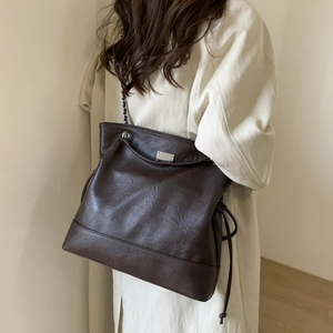 Détail du sac cabas vintage marron avec chaîne en métal et cordon de serrage