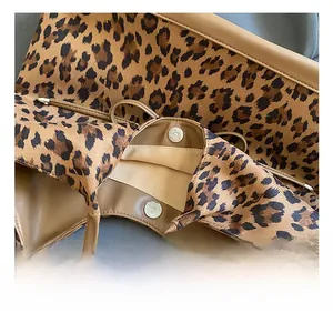Detail of metal magnetic clasp and leopard print suede fabric on vintage tote bag