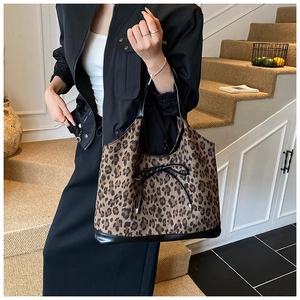 Detail of leopard print tote bag with bow accent and black leather handles