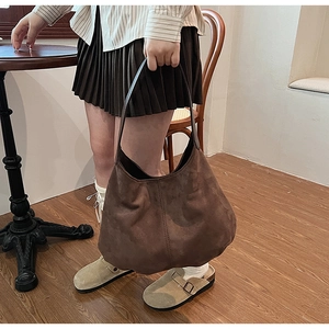 Close-up of large dark brown suede tote bag showing its matte texture and spacious design