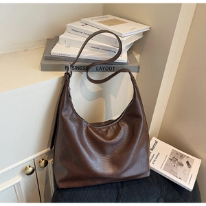 Detail of dark brown vintage Hobo bag with wrinkled texture and wide shoulder strap