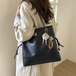 Détail du grand sac cabas noir en cuir avec bandoulière chaîne et pendentif peluche mignon