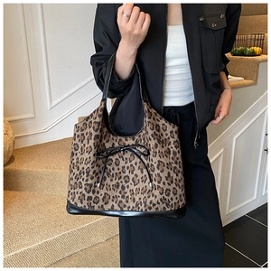 Detail of leopard print tote bag featuring a decorative black bow and spacious interior