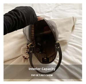 Internal capacity of the vintage leather shoulder bag showing striped lining and items