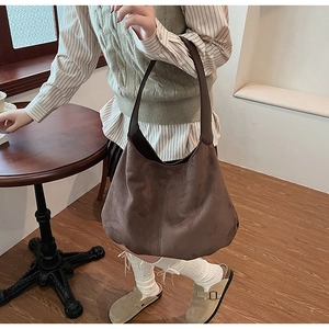 Detail of the vintage brown suede tote bag showing soft texture and slouchy crescent shape